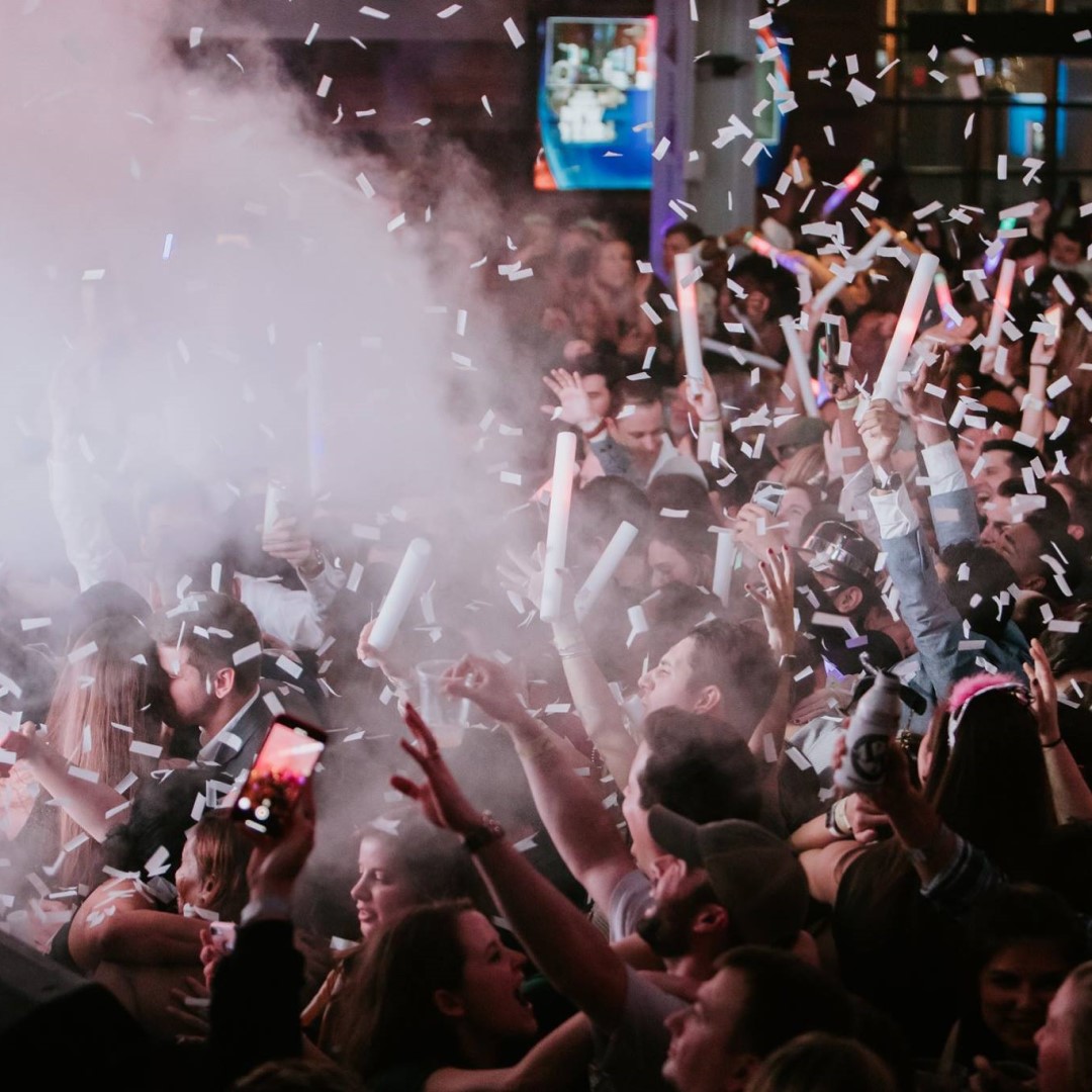 Confetti coming down on crowd at New Year's Eve party.